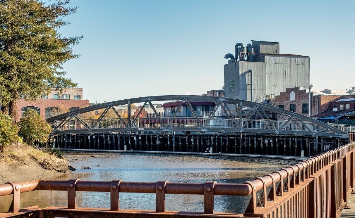 Petaluma river looking south with mill and old brick buildings and an old railroad trestle