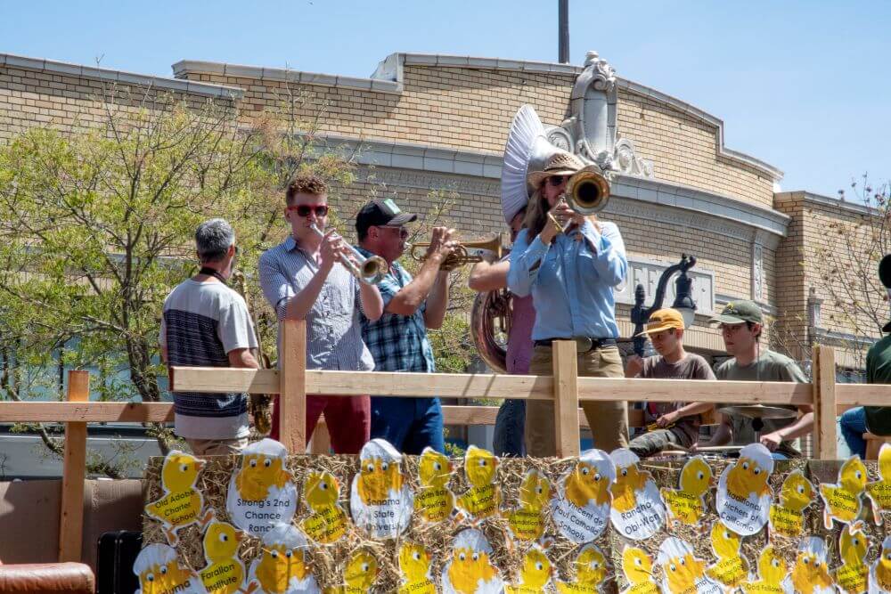 Band with brass section playing on a parade float