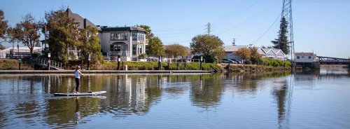 Calm river with buildings and trees.