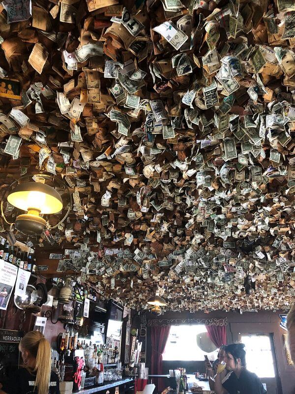 Bar ceiling with dollar bills dangling from it.