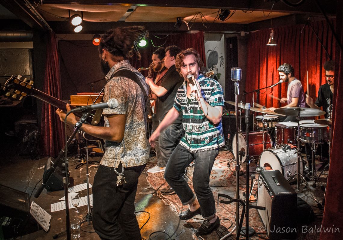 6-piece band performing on the big easy stage. Singer looking at the camera.