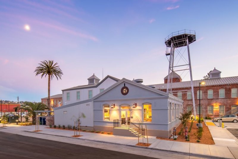 Historic building with palm tree and water tower with lights on inside