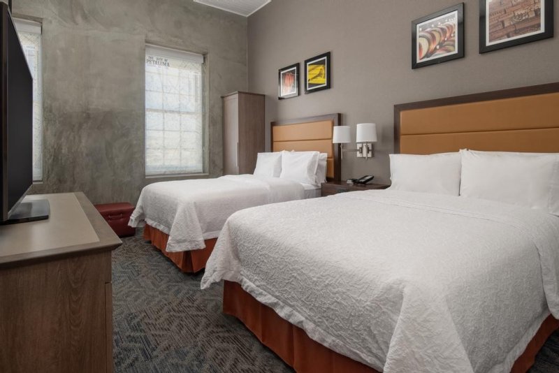 Hotel room with two beds with white bedspreads