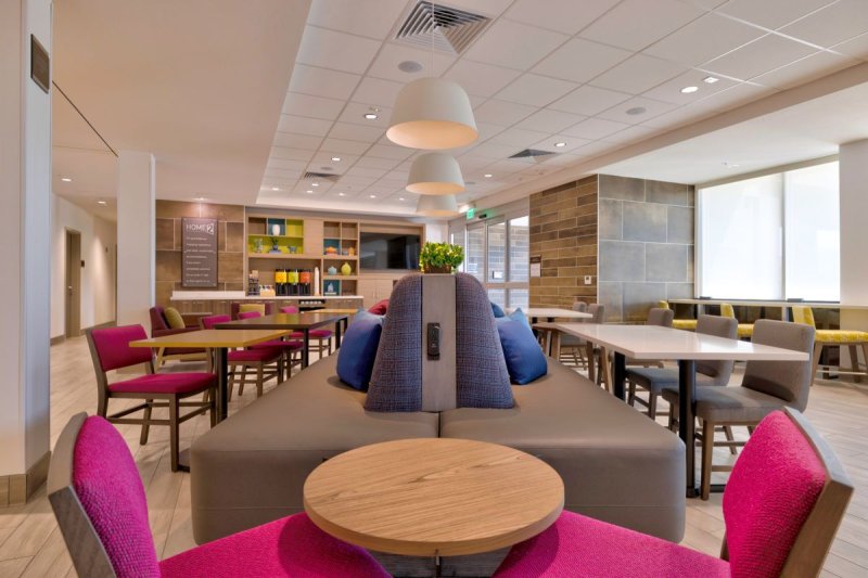 Common area, with light colored flooring and colorful and cushy furnishings.