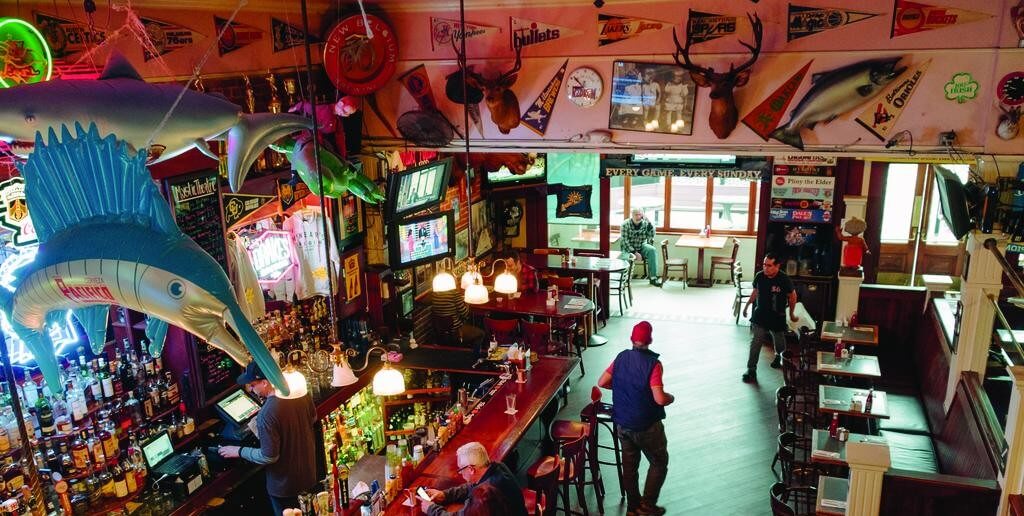Interior of saloon with booths. Mounted dear and fish, pennants,
 and other western decorations cover the walls.