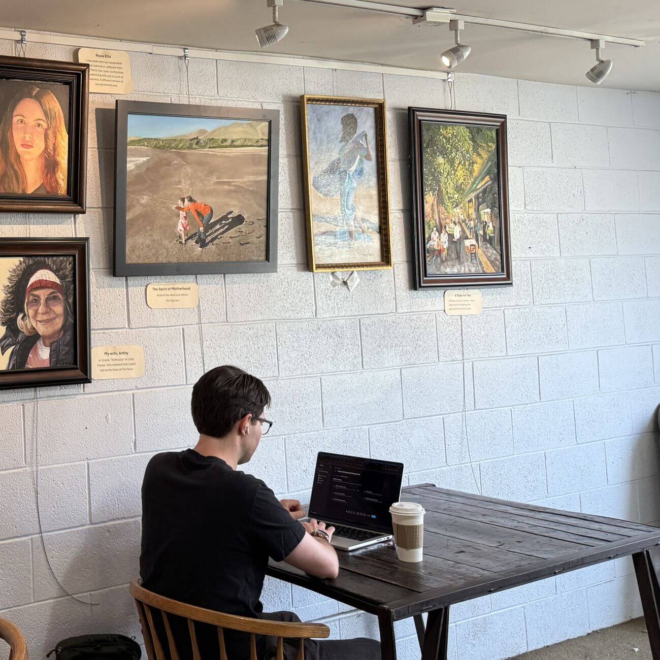 Person working in art-filled café