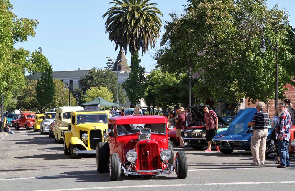 Classic trucks at the head of a line classic vehicles in a classic car cruise