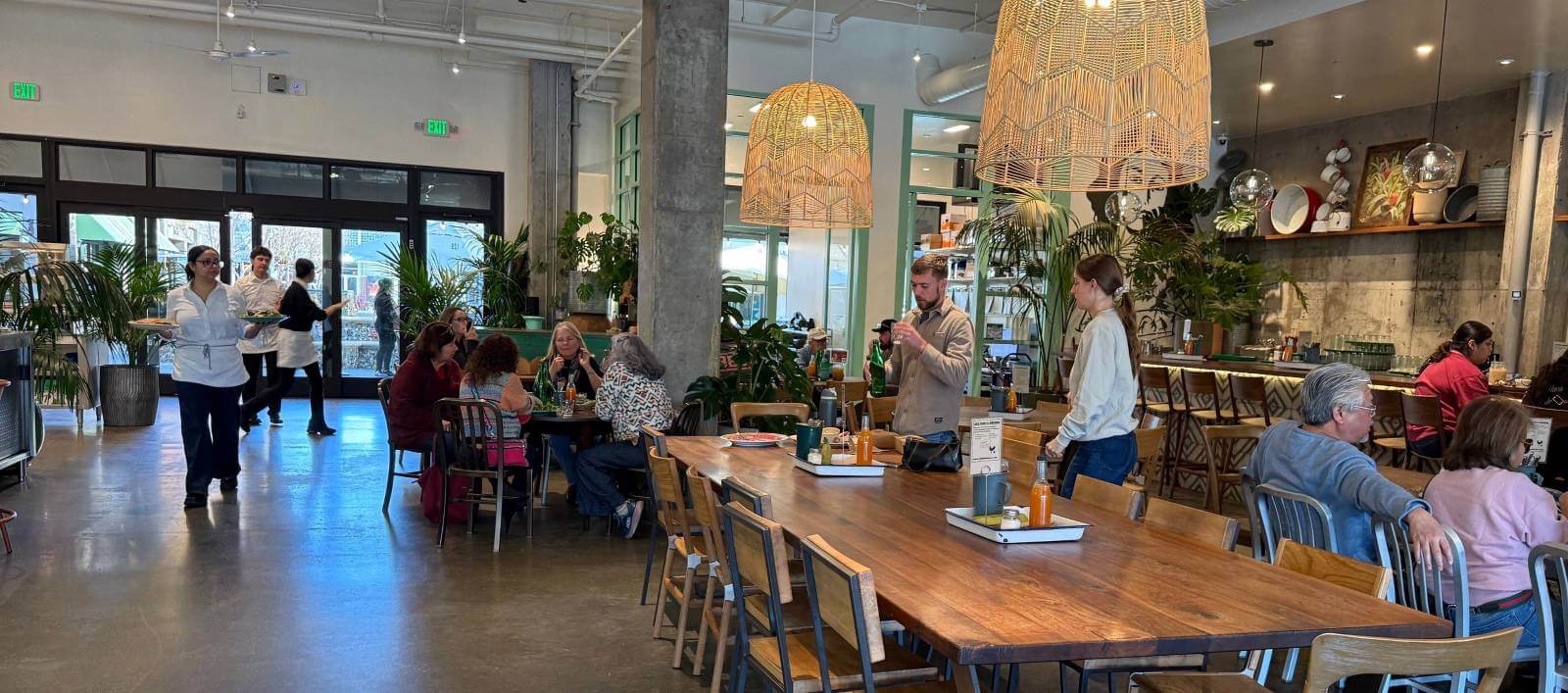 Busy restaurant with tropical decor.