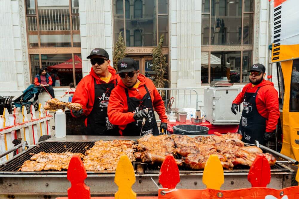 Men in aprons tending a bbq at an outdoor event