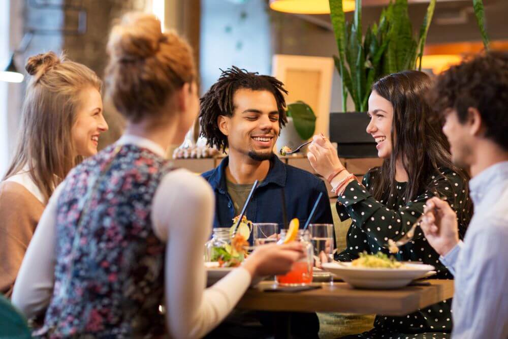 Five smiling diners at a casual restaurant