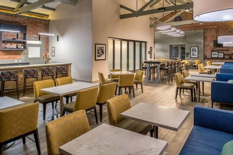 Light colored dining area with high ceilings and bar