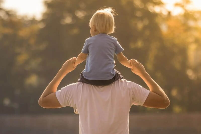 Child on father's shoulders outdoors