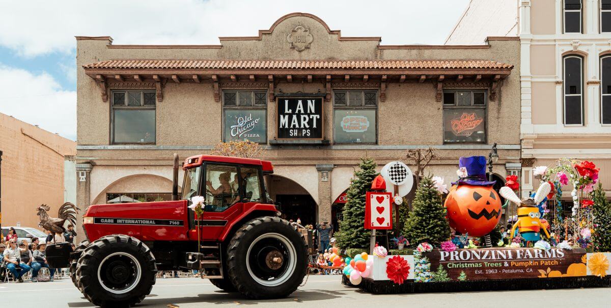 Red tractor pulling colorful float in historic downtown parade