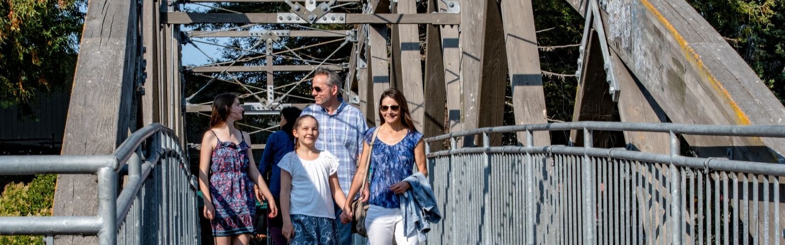 Family of four walking on foot bridge