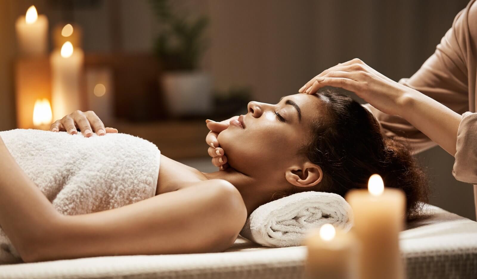 Woman on table having relaxing spa treatment with candles.